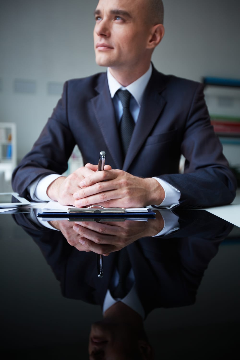 Na imagem: Homem de terno com ar de liderança olha para o horizonte